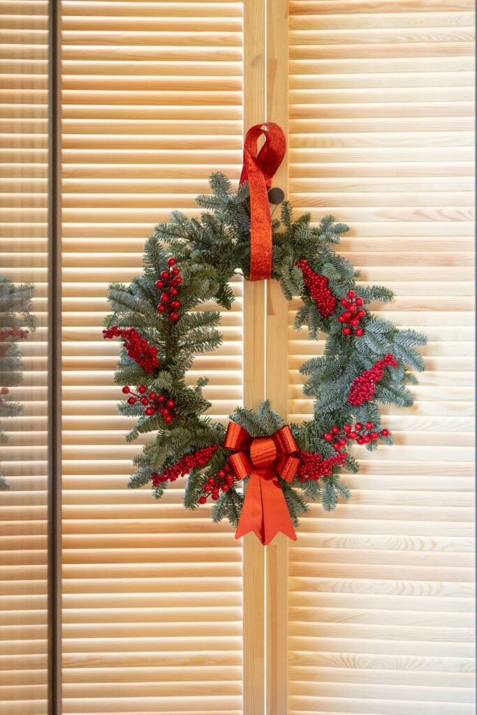 Beautiful Christmas wreath on wooden shutters on the window